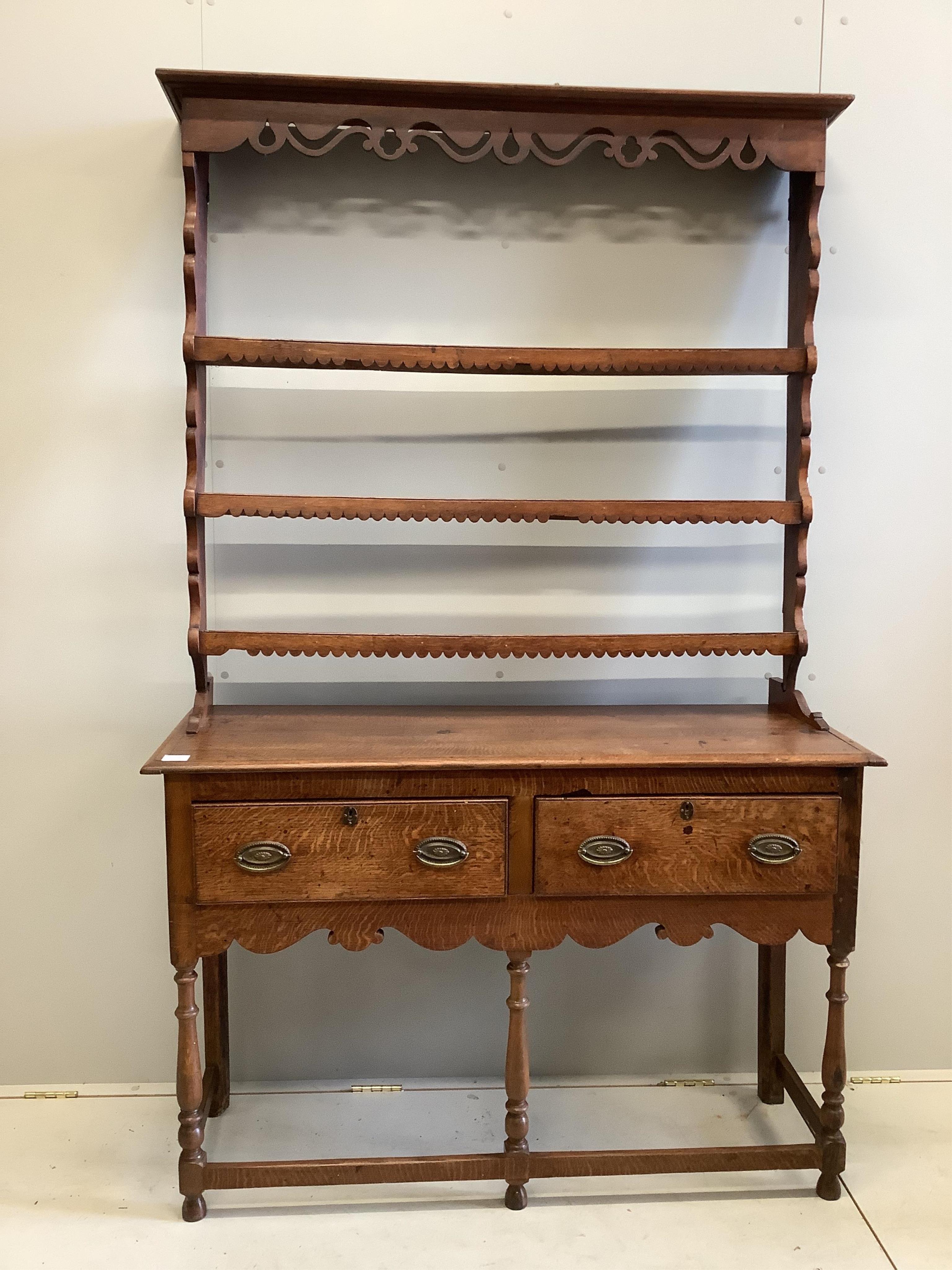 A George III style oak dresser, of small proportions, fitted with twin drawers and shaped apron, raised on turned supports, together with an associated wall rack, width 155cm, depth 44cm, height 196cm. Condition - fair